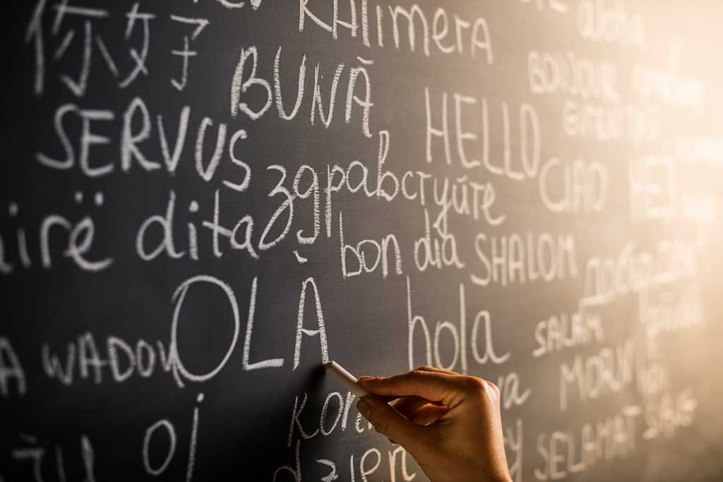 'Hello' written in many languages on chalkboard.